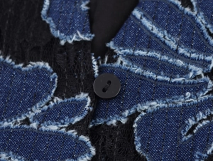 Vue macro détaillée du patchwork de denim avec dentelle noire et bouton fonctionnel