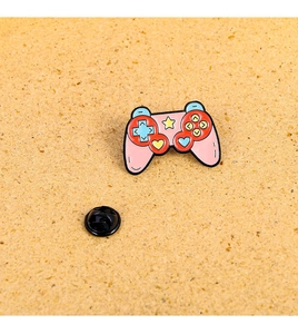 Detailed view of pink game controller enamel pin with stars and rubber back clasp