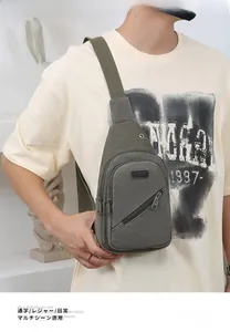 Close-up of military green canvas sling bag with multiple zippers and Sport label