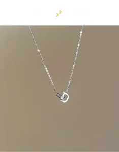 Détail du collier en titane argenté avec anneau serti de cristaux et pendentif lettre D