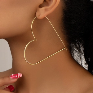 Minimalist large gold heart hoop earrings for women with polished finish on model