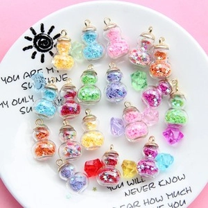 Macro shot of colorful gourd-shaped glass charms with star sequins in a white tray