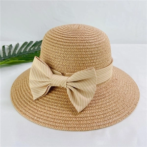 Detailed view of natural woven straw hat featuring a beige striped ribbon bow decoration