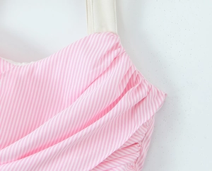 Detailed view of pink and white striped fabric with ruched texture and cream straps