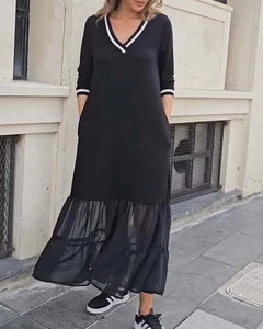 Détail du col en V à rayures blanches et ourlet en tulle sur une robe midi noire