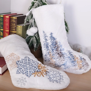 White plush Christmas stockings with blue and gold snowflakes and tree embroidery
