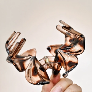 Detail view of large tortoiseshell claw clip with amber brown floral petal design