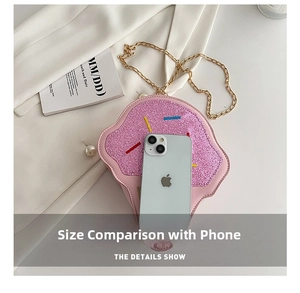Pink ice cream crossbody bag with glitter finish and gold chain next to a phone