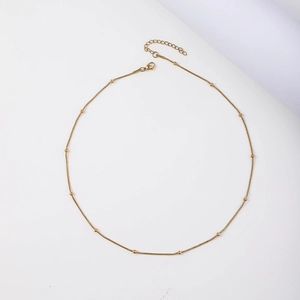 Detail of 18K gold-plated stainless steel snake chain necklace with small beads and clasp