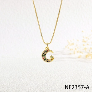 Close-up of golden moon and star pendant necklace set with vibrant colorful crystals