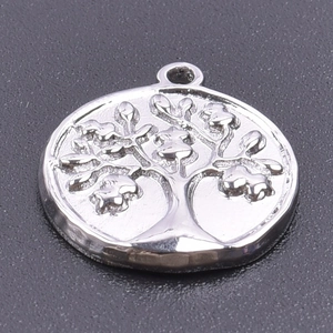 Detailed macro view of silver stainless steel tree of life charm with polished finish