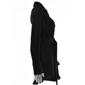 Detail view of black ruffled blouse featuring textured crinkle fabric and waist tie design