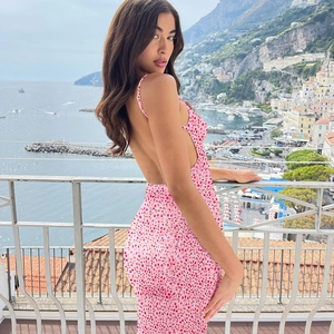 Détail de la robe à fleurs dos nu montrant l'imprimé floral rose et les bretelles
