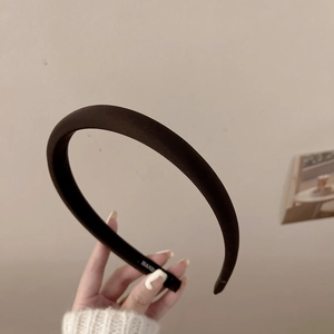 Détail d'un serre-tête rembourré marron café avec finition tissu doux et logo intérieur
