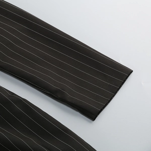 Detailed macro view of black pinstripe fabric texture and stitching on the formal dress