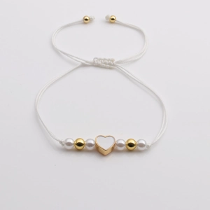 Adjustable woven bracelet with gold heart charm, white pearls, and gold beads