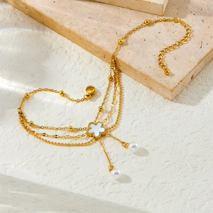 Layered gold-plated anklet featuring white shell clover charm and pearl fringe tassels
