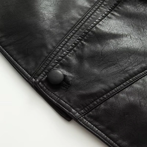 Macro detail of high-quality black faux leather texture with precise stitching and matte button