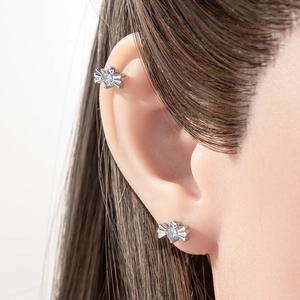 Orecchini a fiocco in argento con zircone blu indossati su lobo e cartilagine