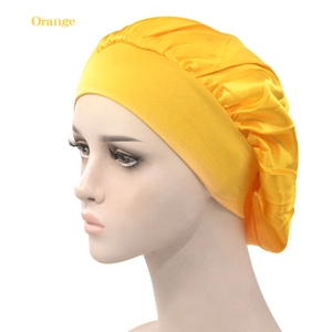 Detail view of smooth orange satin sleep cap with wide elastic band on a model head
