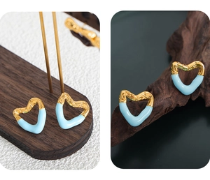 Close-up of bamboo-textured gold heart earrings with light blue enamel finish