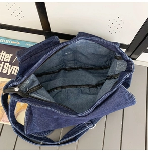 Vista interna di una spaziosa borsa a tracolla in denim blu con fodera e tasche interne