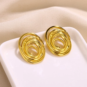 Macro shot of gold-plated spiral oval earrings with unique layered metal texture