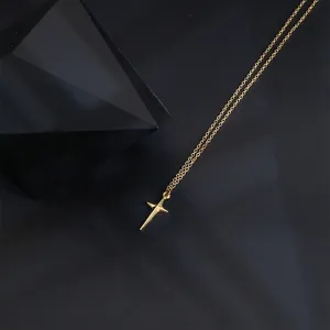 Macro shot of gold four-pointed star pendant necklace on dark background