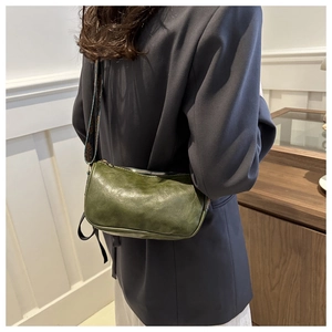 Detail of green soft leather crossbody bag featuring a stylish floral print wide strap