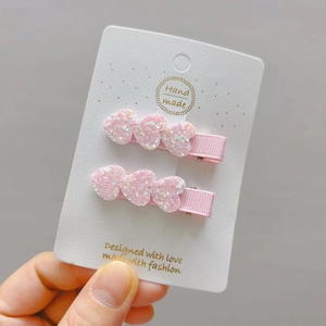 Detail of pink glitter heart hair clips with soft ribbon-wrapped metal base for girls