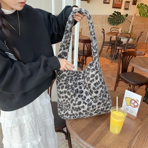 Detailed view of women's leopard print faux fur tote bag in a casual cafe setting
