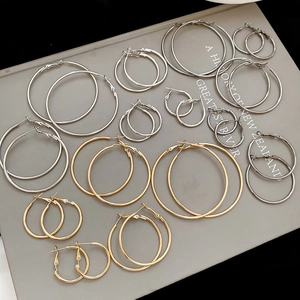 Classic silver and gold hoop earrings in various sizes arranged on a vintage book