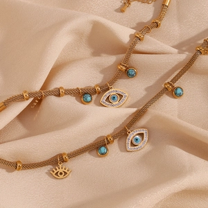 Detailed macro view of 18K gold plated mesh chain with turquoise beads and evil eye charm
