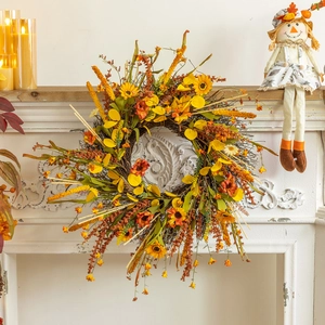 Couronne de récolte automnale avec tournesols jaunes et feuilles oranges sur cheminée