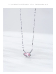 Detailed close-up of oval pink morganite pendant with silver chain on silk background