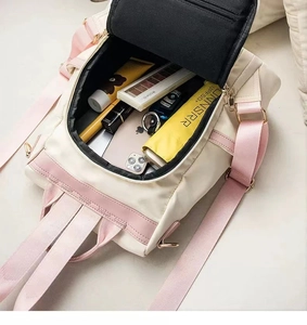 Spacious main compartment of nylon backpack showing daily items like phone and umbrella