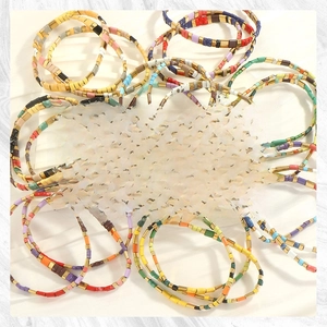 Detailed stack of bohemian Tila bead bracelets with colorful enamel and gold spacers