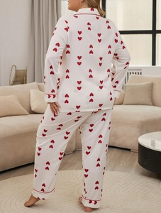 Back view of women's heart print pajama set with red piping in a cozy home setting