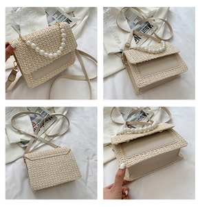 Detail view of woven straw crossbody bag with pearl handle and leather strap accents
