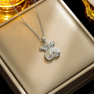 Modern silver hollow bear pendant necklace with sparkling zircons on a jewelry box