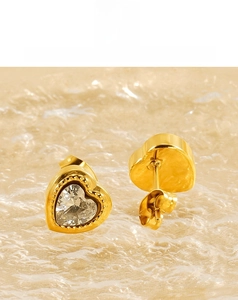 Detail shot of gold heart stud earrings with cubic zirconia and beaded edge texture