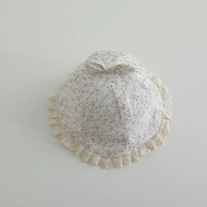 Detailed view of floral baby sun hat with bow decoration and white lace trim edge