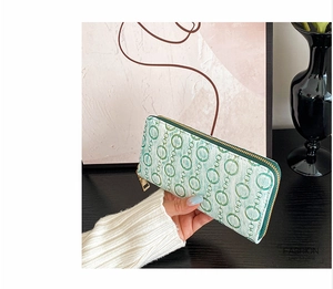 Detail of green embossed PU leather long wallet with gold zipper and chain pattern