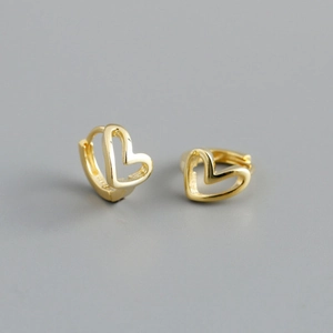 Macro detail of gold-plated hollow heart hoop earrings featuring minimalist geometric design