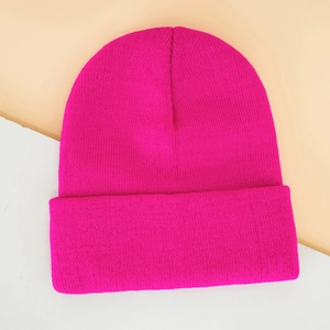 Detail of hot pink ribbed knit beanie featuring thick folded cuff and fine texture