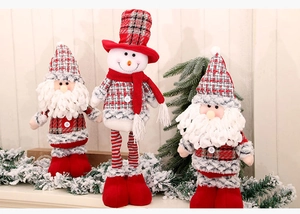 Close-up of plush Santa and snowman dolls with red plaid patterns on a festive wooden backdrop