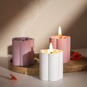 Trois bougies parfumées en forme de fleur sur plateau bois avec lumière naturelle