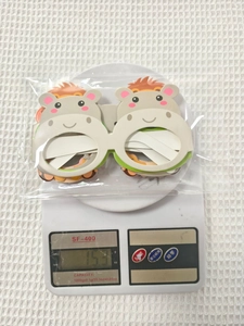 Cute cartoon hippo paper glasses decor showing 15.3g weight on a digital scale