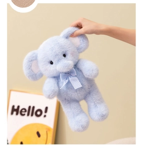 Detailed close-up of a soft light blue plush elephant with a cute checkered bow tie
