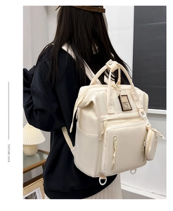 Rear view of a premium cream multifunctional mummy backpack with a matching mini pouch